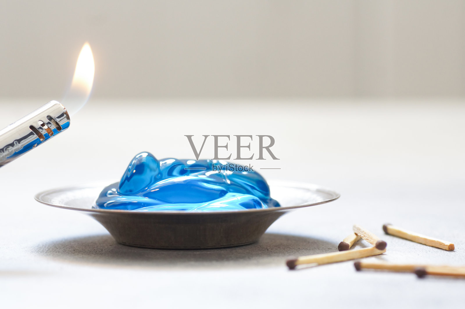 用火柴棍将燃油凝胶倒入金属盘中，蓝色的柴火凝胶，reso照片摄影图片