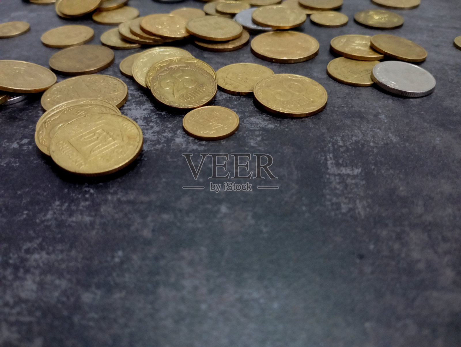 圆形的黄色硬币在黑暗的混凝土背景在照片的顶部。金融的话题和乌克兰小硬币的背景。照片摄影图片