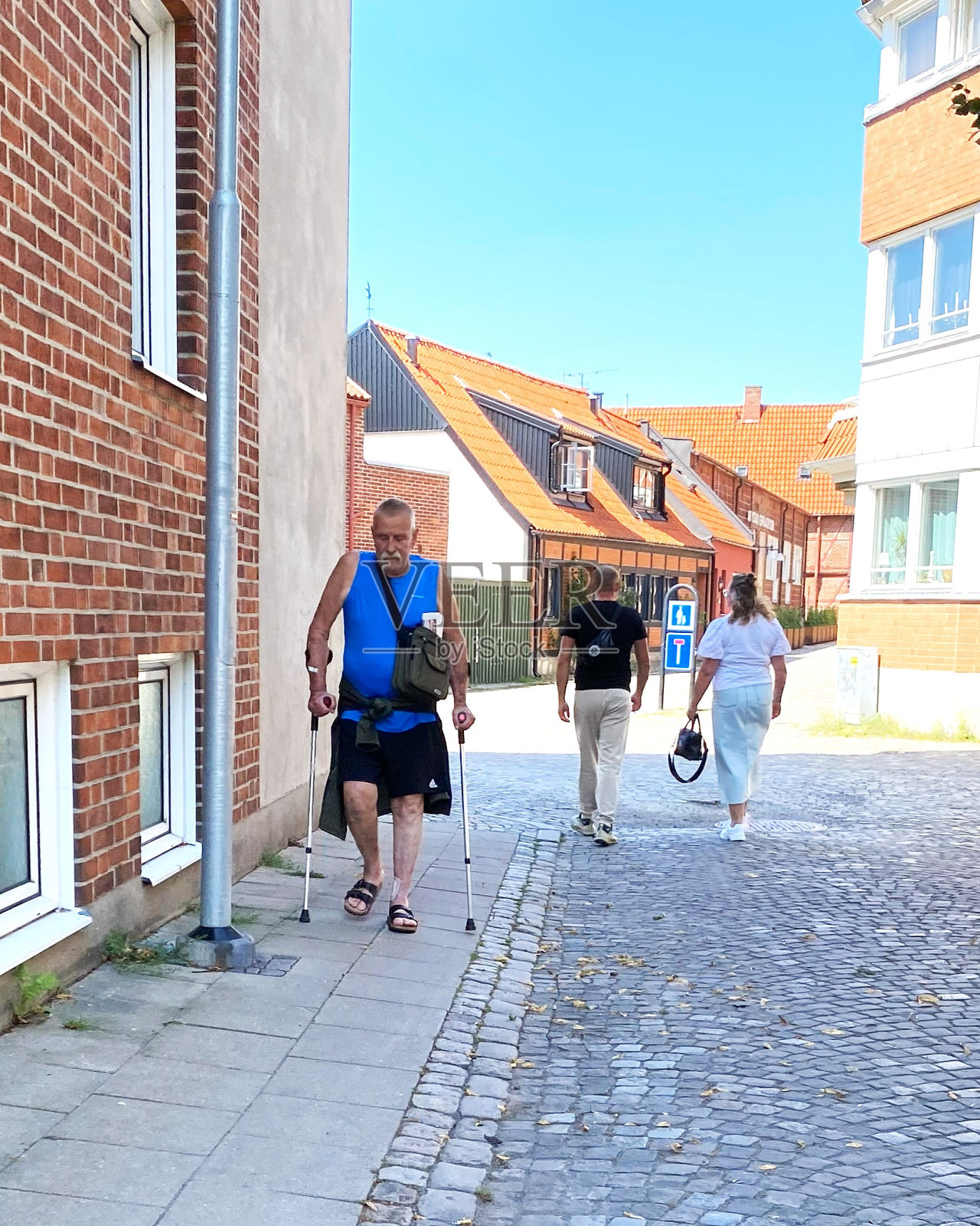 一名男子拄着拐杖走在伊斯塔德的街道上照片摄影图片