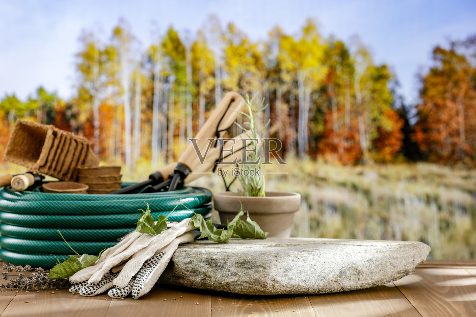 园艺设备和石头平基座与空复制空间的产品。木桌和秋天的景观背景。照片摄影图片