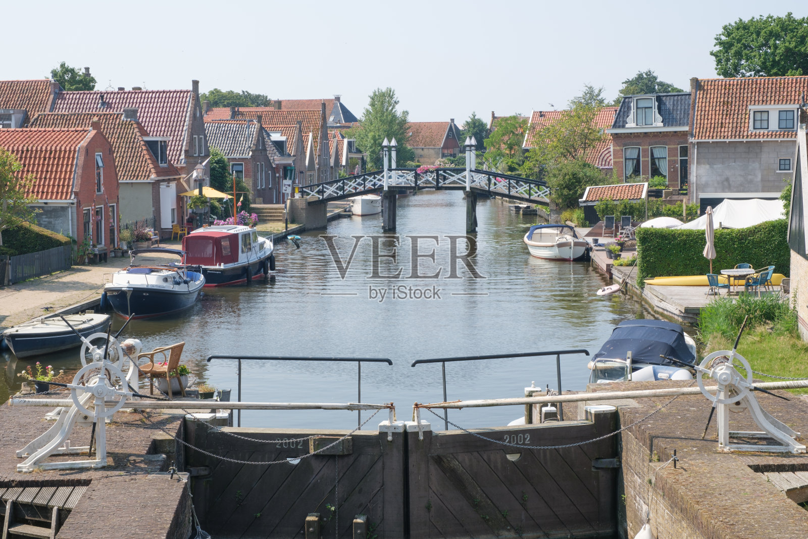 在荷兰弗里斯兰群岛十一城市之一的欣德洛彭旧港口的锁和人行桥上的景色照片摄影图片