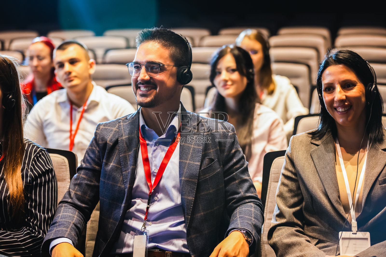 商务人士在会议中心的新闻发布会上戴着耳机翻译。照片摄影图片