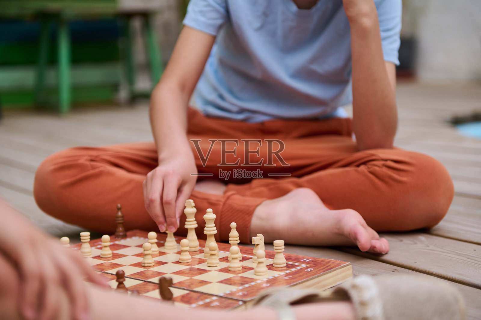 孩子们穿着休闲装在户外的木甲板上下棋的特写照片摄影图片