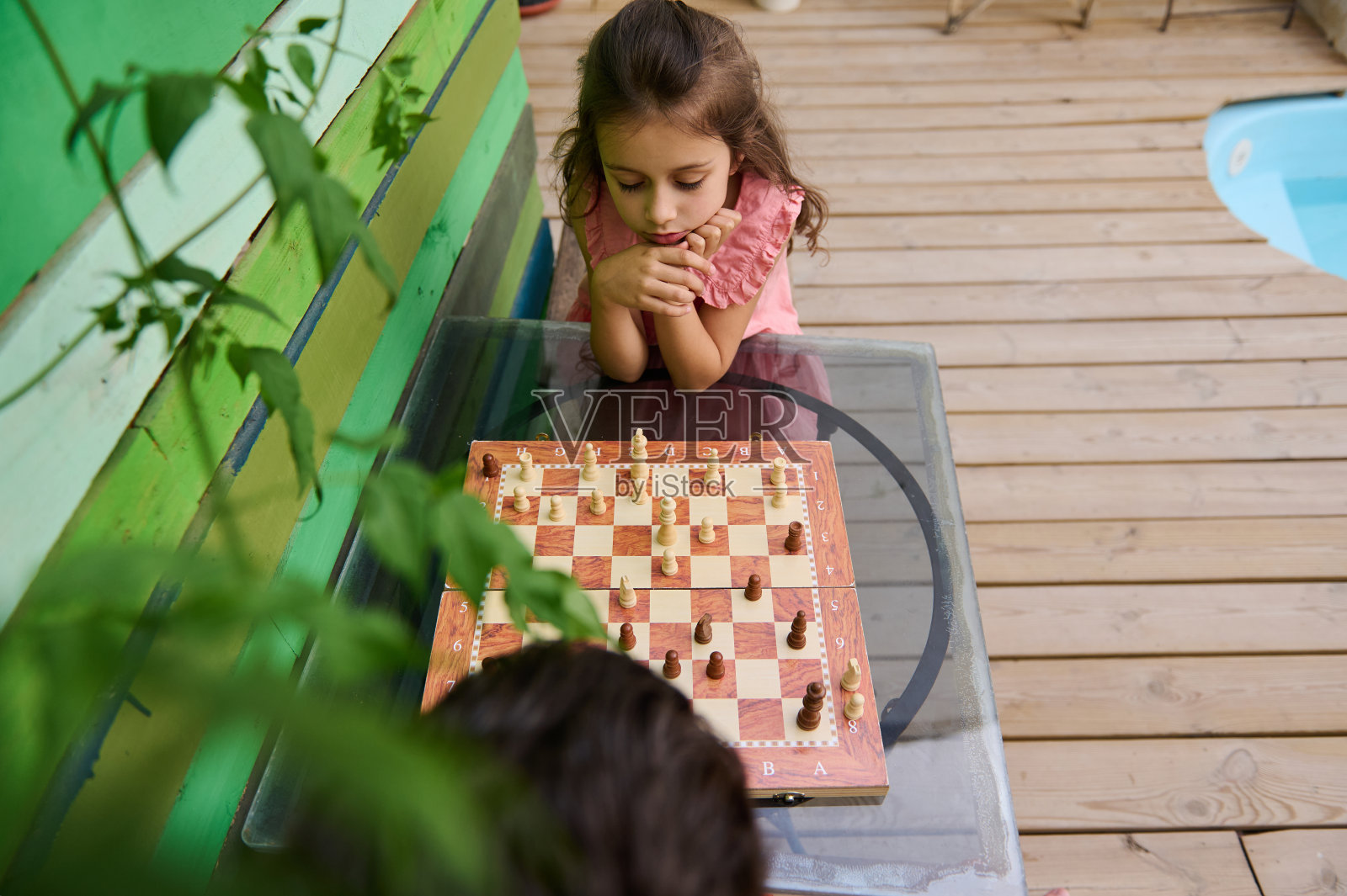 小女孩在户外专心下棋照片摄影图片