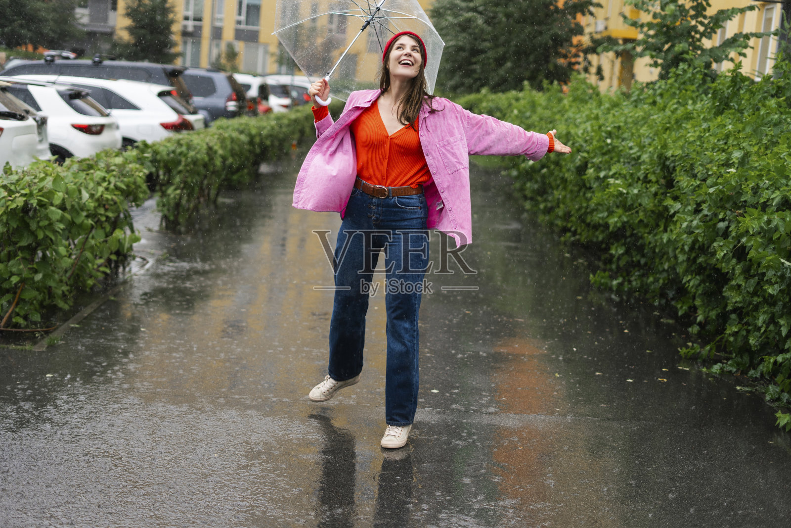 快乐的女人在夏雨中漫步，欢欣鼓舞照片摄影图片