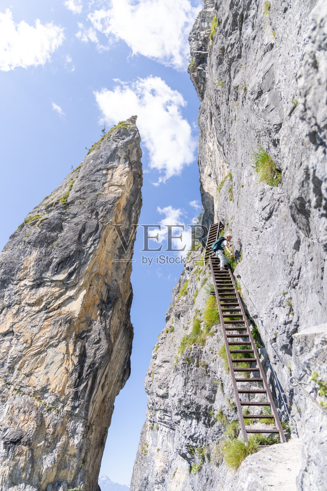 登山者在山路上攀爬高高的金属梯子照片摄影图片