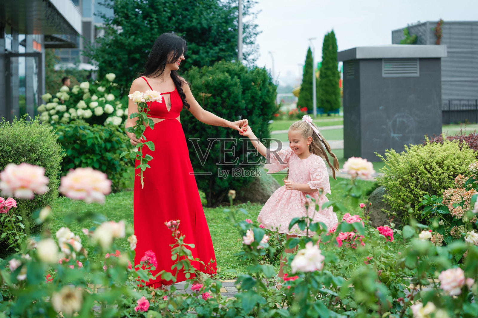 母亲和女儿在充满玫瑰的花园里享受美好的一天照片摄影图片