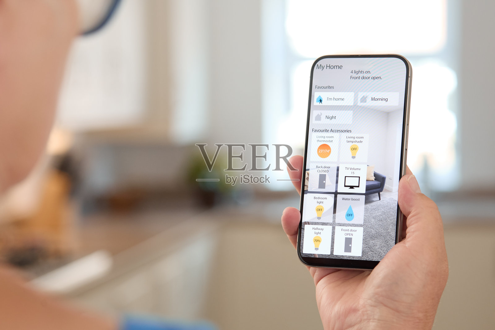 在现代客厅环境中使用智能手机控制智能家居设备照片摄影图片