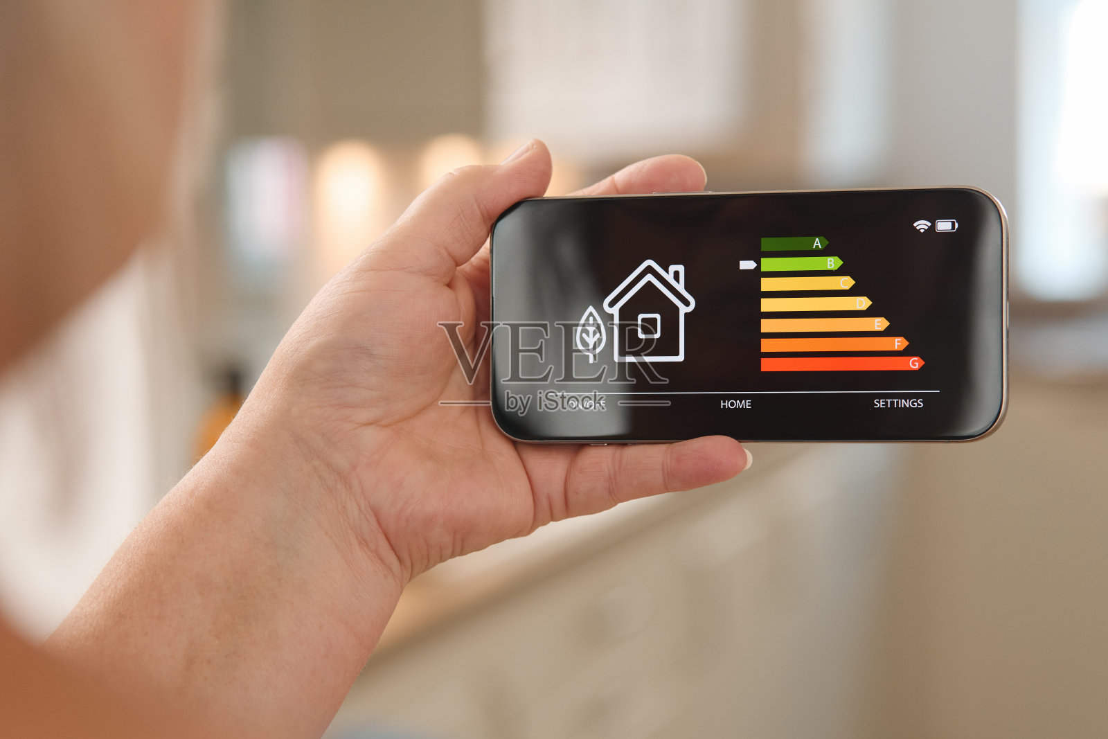 在舒适的家居环境下，通过智能手机界面监测白天的能源消耗照片摄影图片