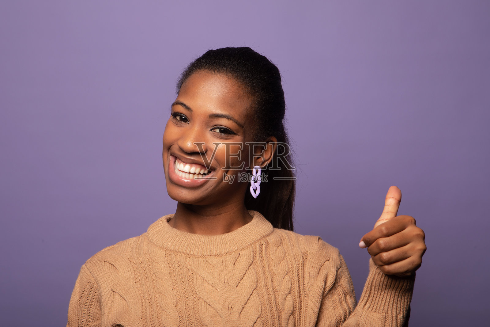 有趣的黑人妇女在紫色背景上显示ok的手势。照片摄影图片