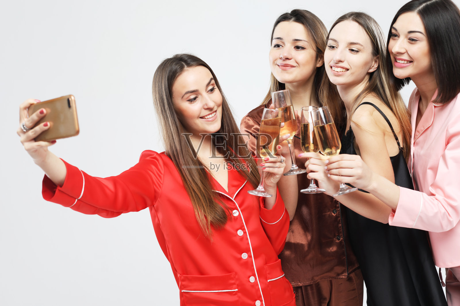 四个穿着睡衣的快乐朋友喝着咖啡，自拍。照片摄影图片