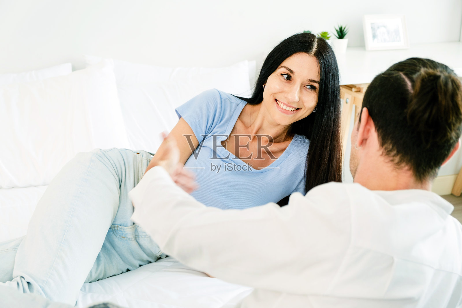 幸福的白人夫妇坐在舒适的床上，放松地看着对方的眼睛，微笑着。热恋中的浪漫情侣看着对方。夫妻在关系中度过了美好的时光照片摄影图片