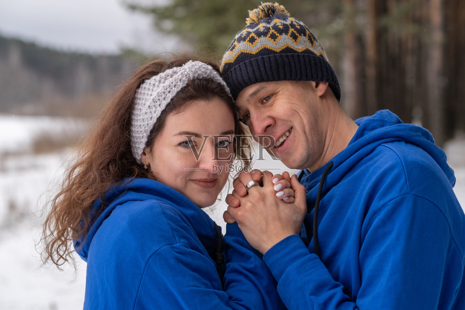 在寒冷的冬天里，一对幸福的情侣在户外摆姿势。照片摄影图片