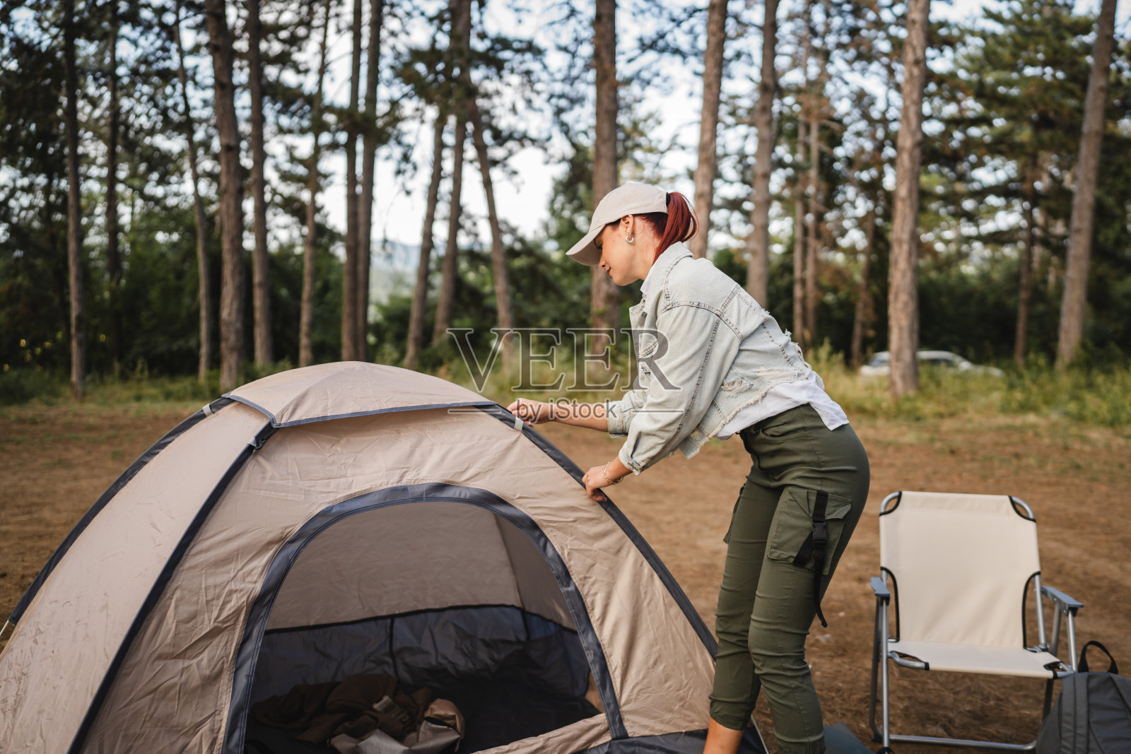 年轻女子在大自然中搭起帐篷，准备在森林里露营照片摄影图片