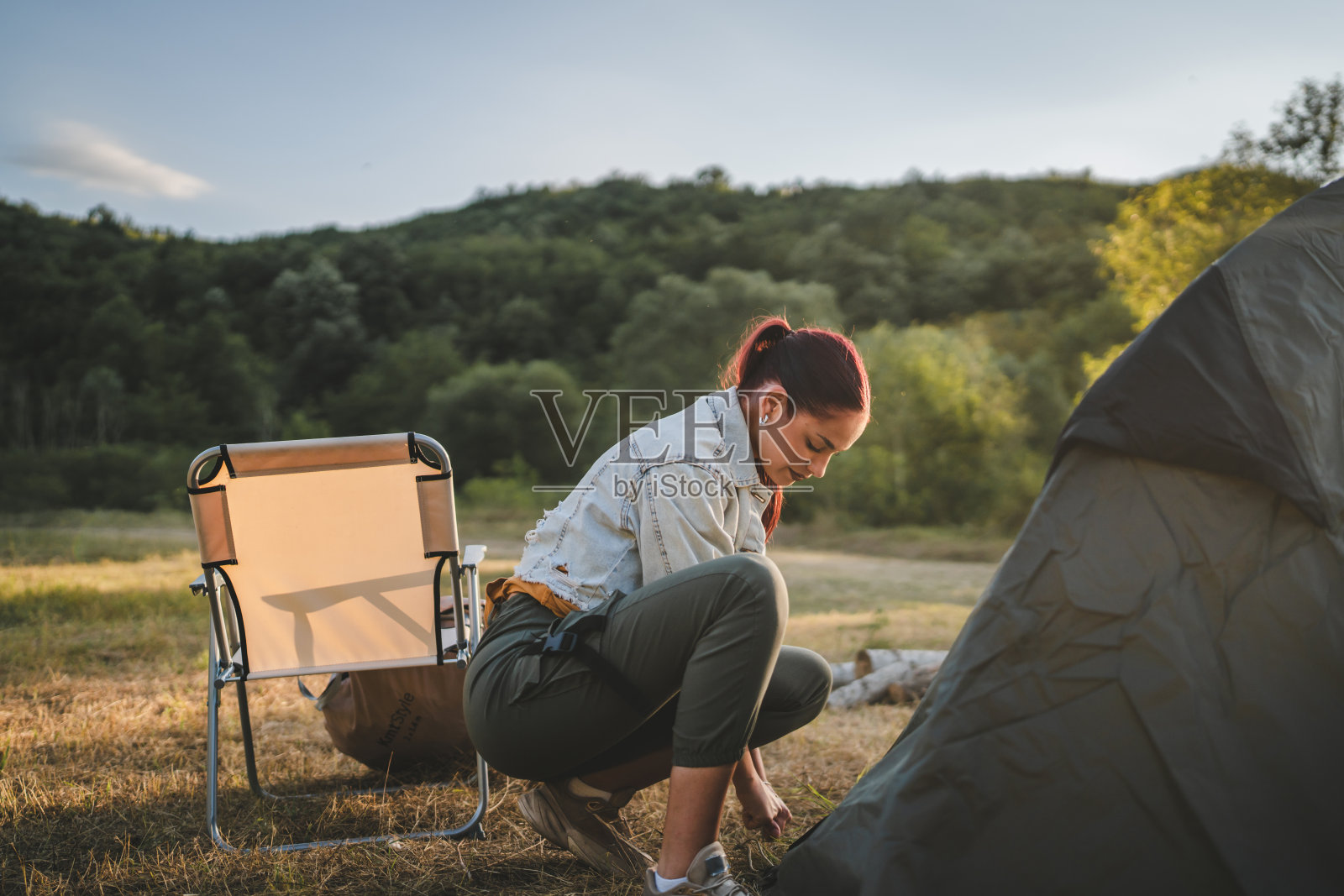 年轻女子在大自然中搭起帐篷，准备在森林里露营照片摄影图片