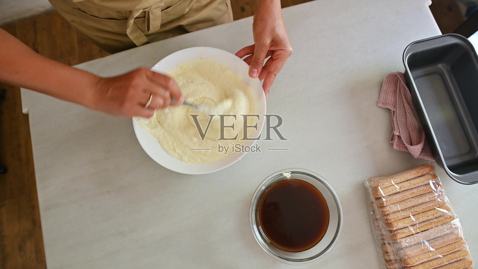 在厨房里用马斯卡彭奶酪调制意大利甜点提拉米苏的人照片摄影图片