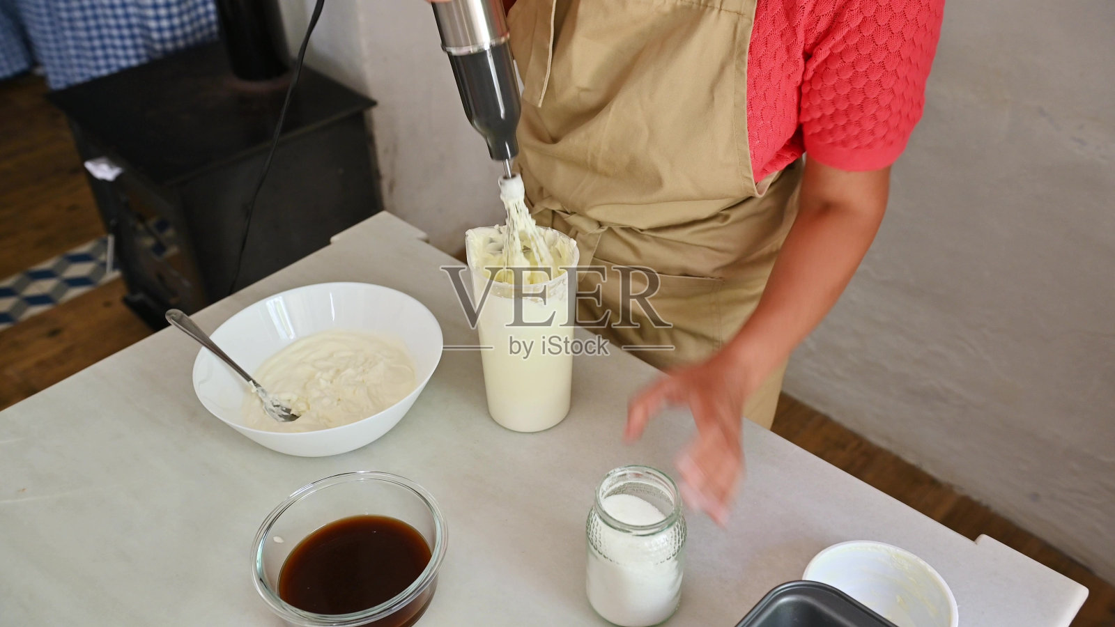 在厨房里用浸入式搅拌器准备意大利菜的人照片摄影图片