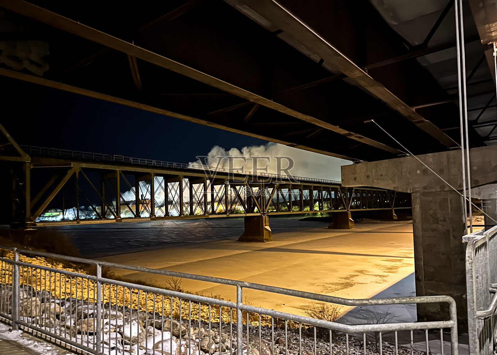 火车在冰冻河上的桥上照片摄影图片