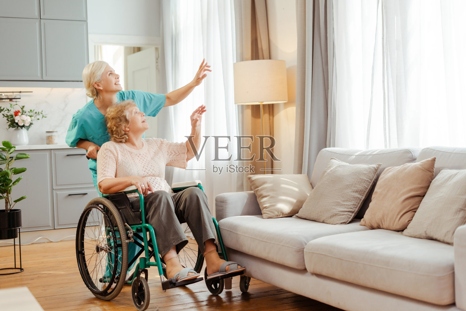 护士扶着轮椅上的老妇人指着什么照片摄影图片