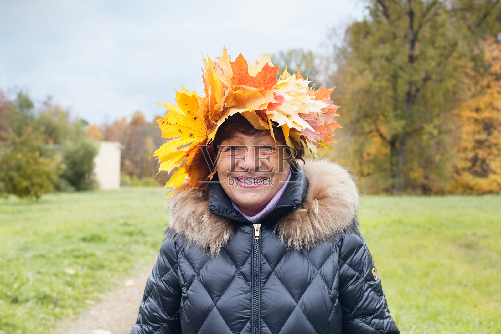 秋叶中老年妇女的特写肖像。照片摄影图片