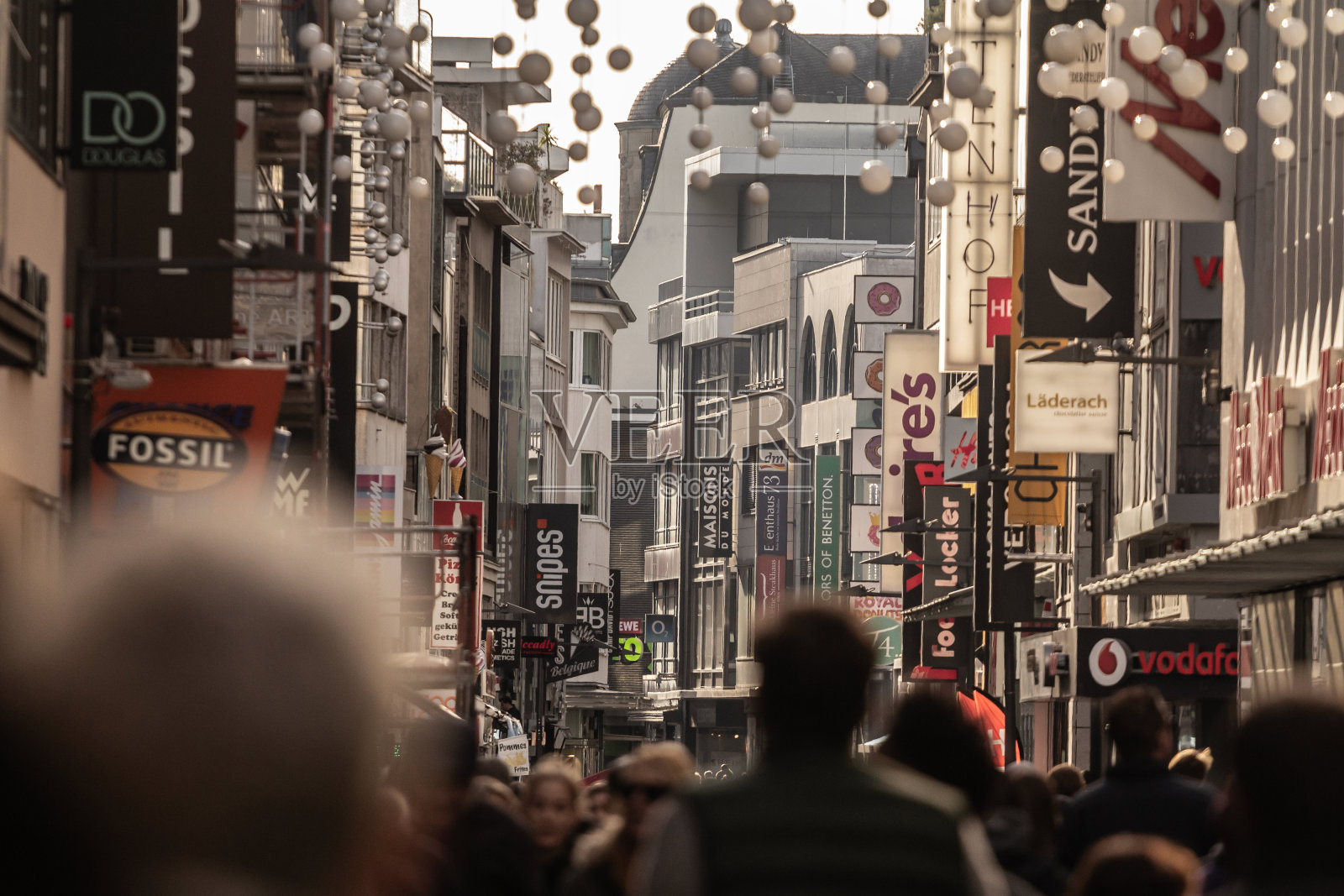 选择性模糊的人群走在hohestrasse街与商店和商店。hohestrasse是科隆老城的购物街，主街。照片摄影图片