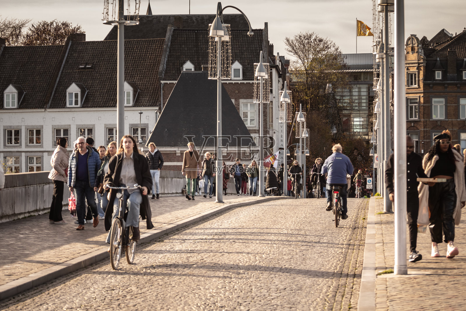 人们在马斯特里赫特市中心的Sint Servaasbrug桥上骑自行车。荷兰人以自行车为交通工具而闻名。照片摄影图片