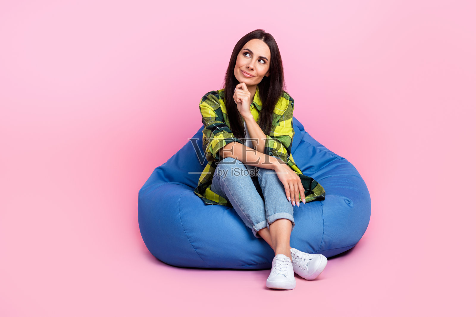 全身照片的梦幻可爱的女人穿着格子衬衫豆袋手臂下巴看起来空的空间孤立的粉红色背景照片摄影图片