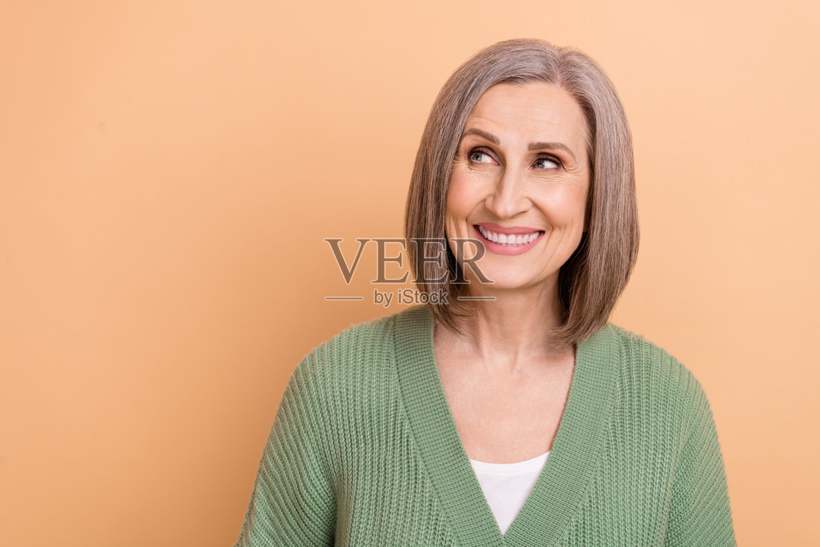 肖像资深迷人的女士卡其开衫微笑灰色的头发看起来空的空间购物提供孤立的米色背景照片摄影图片