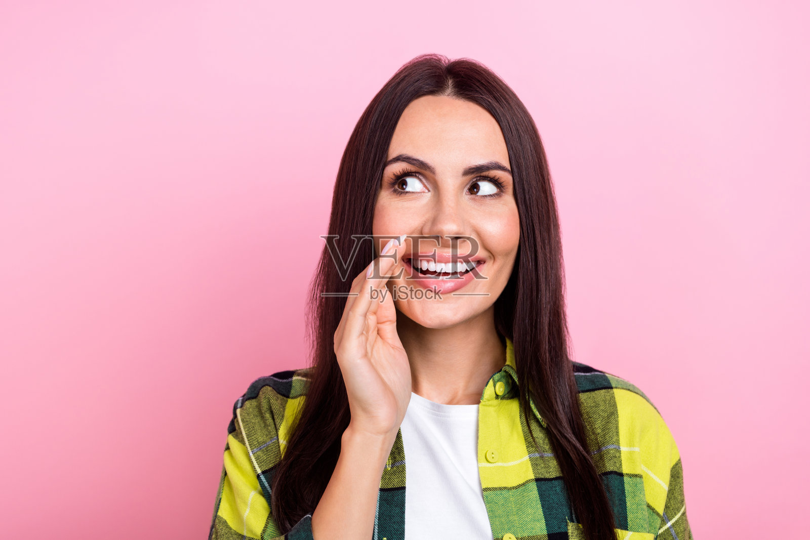 开朗有趣的八卦人物的肖像，长发型，穿黄色夹克，看起来空无一人，在粉红色的背景上孤立地讲述谣言照片摄影图片