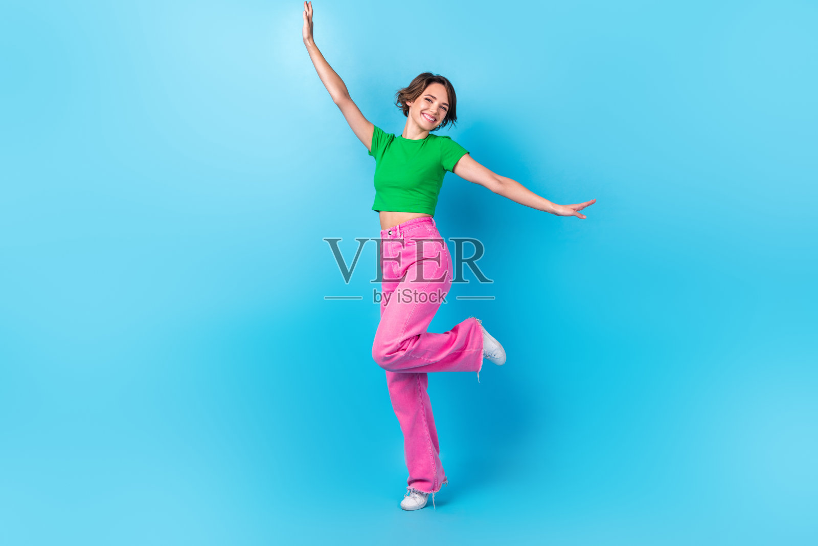 长干部微笑快乐好心情的女孩跳舞积极有乐趣穿着时髦的服装寒心迪斯科舞厅孤立在蓝色的背景照片摄影图片