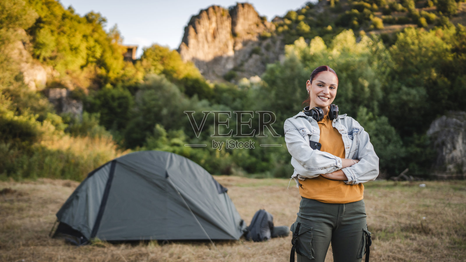 戴着耳机站在帐篷前的年轻女子的肖像照片摄影图片