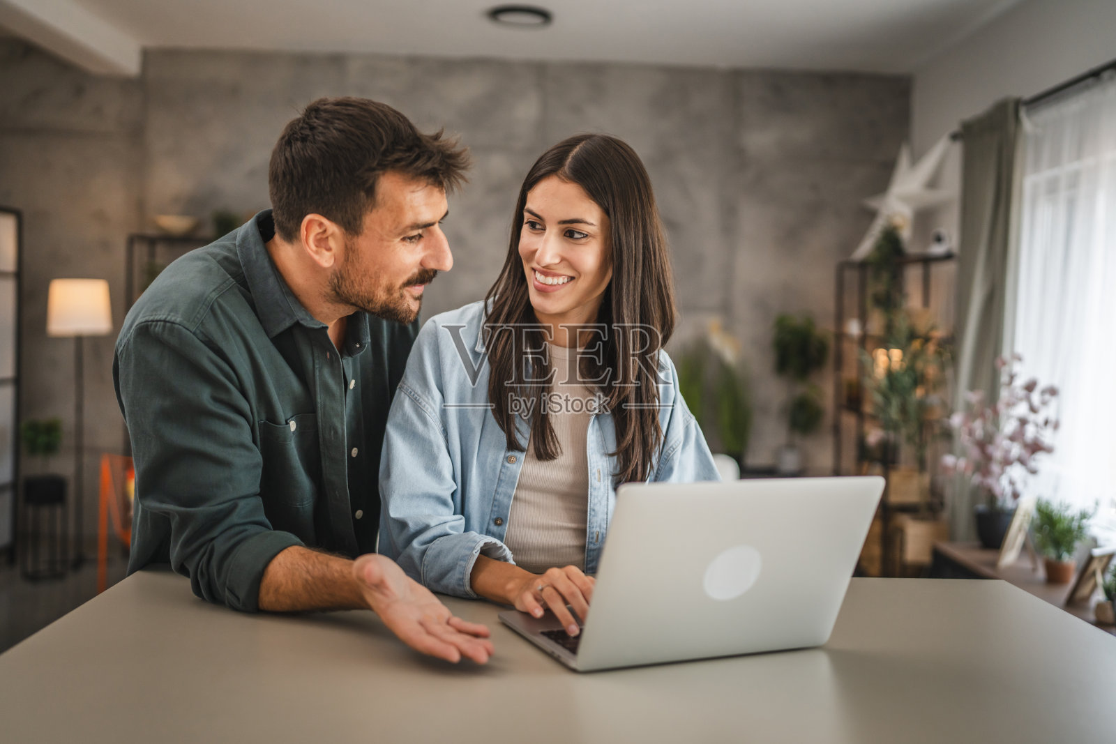 成年高加索夫妇站在家里用笔记本电脑学习照片摄影图片