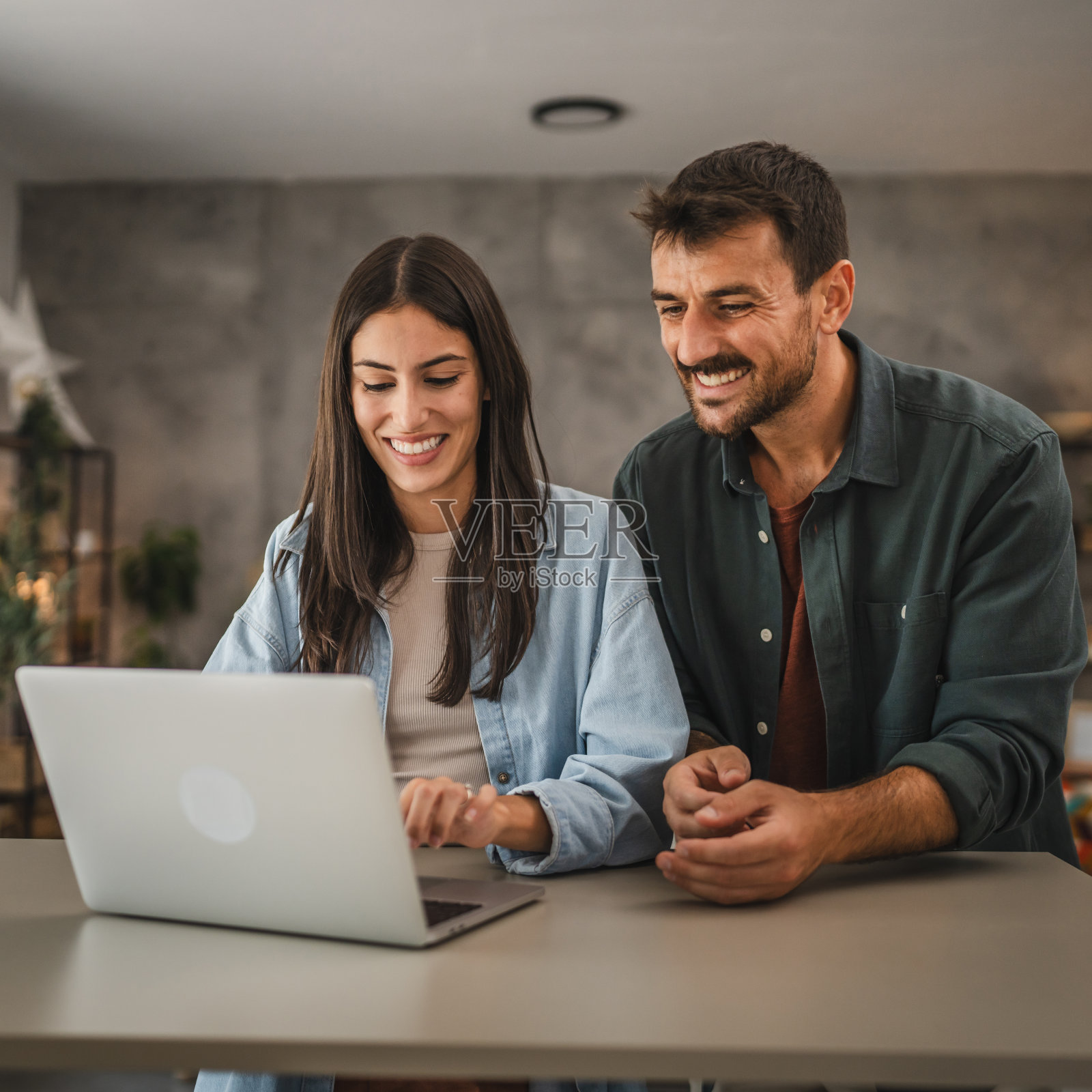 成年高加索夫妇站在家里用笔记本电脑学习照片摄影图片