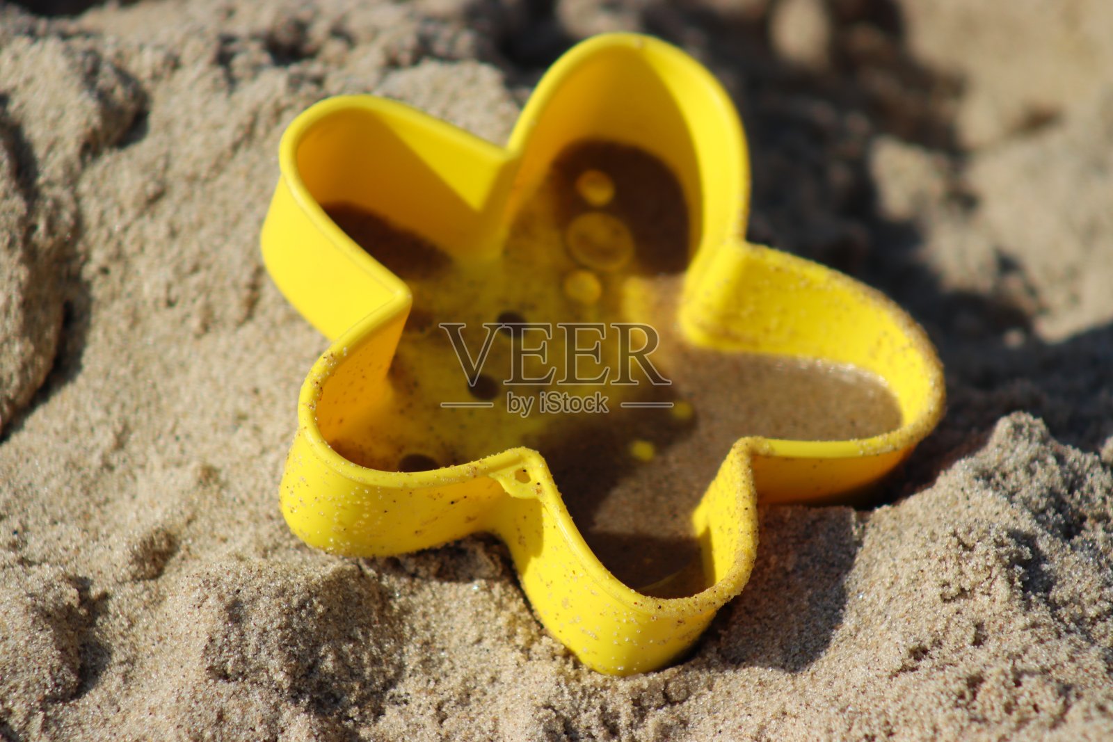 海滩上孩子们的沙玩具。照片摄影图片