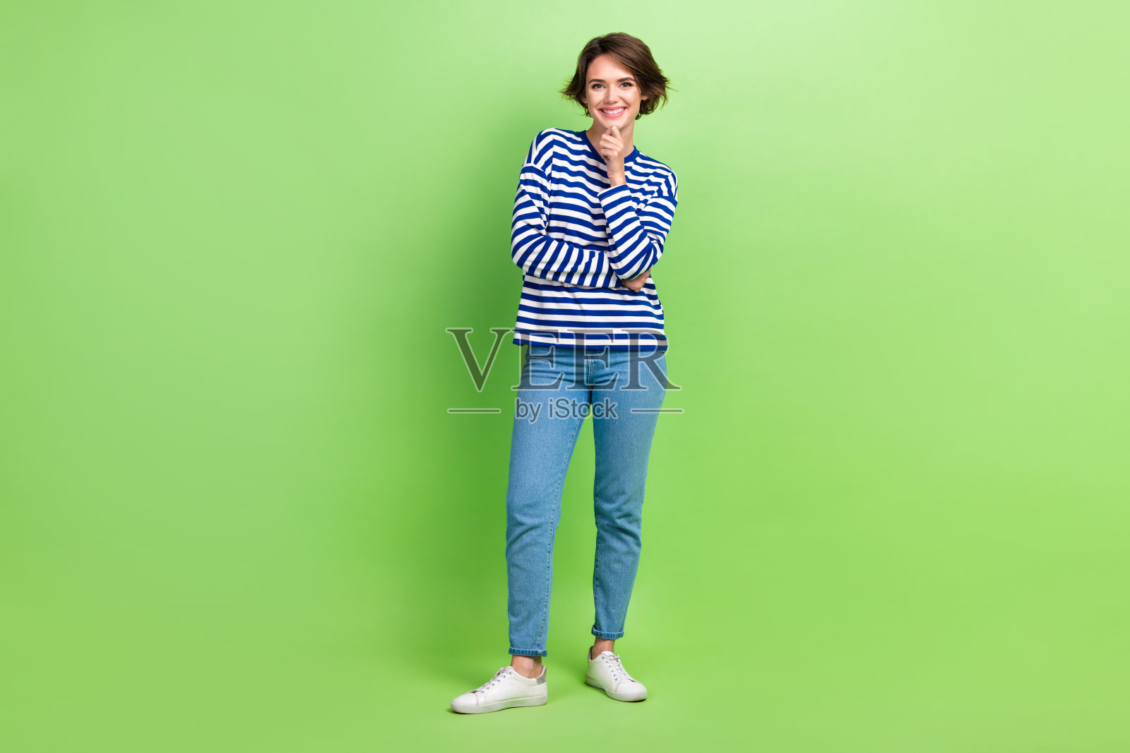 年轻迷人的女人的全身照片鲍勃棕色的头发触摸下巴深思熟虑的姿势穿着新衣服孤立的绿色背景照片摄影图片