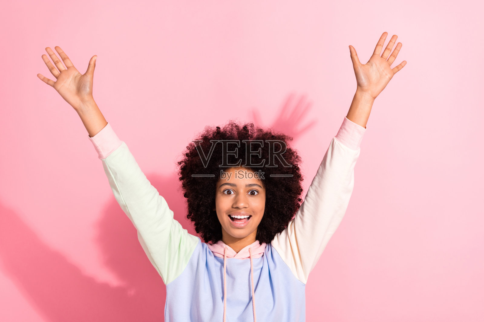 照片相当兴奋的小孩穿着连帽衫微笑上升手臂双手孤立的粉红色背景照片摄影图片