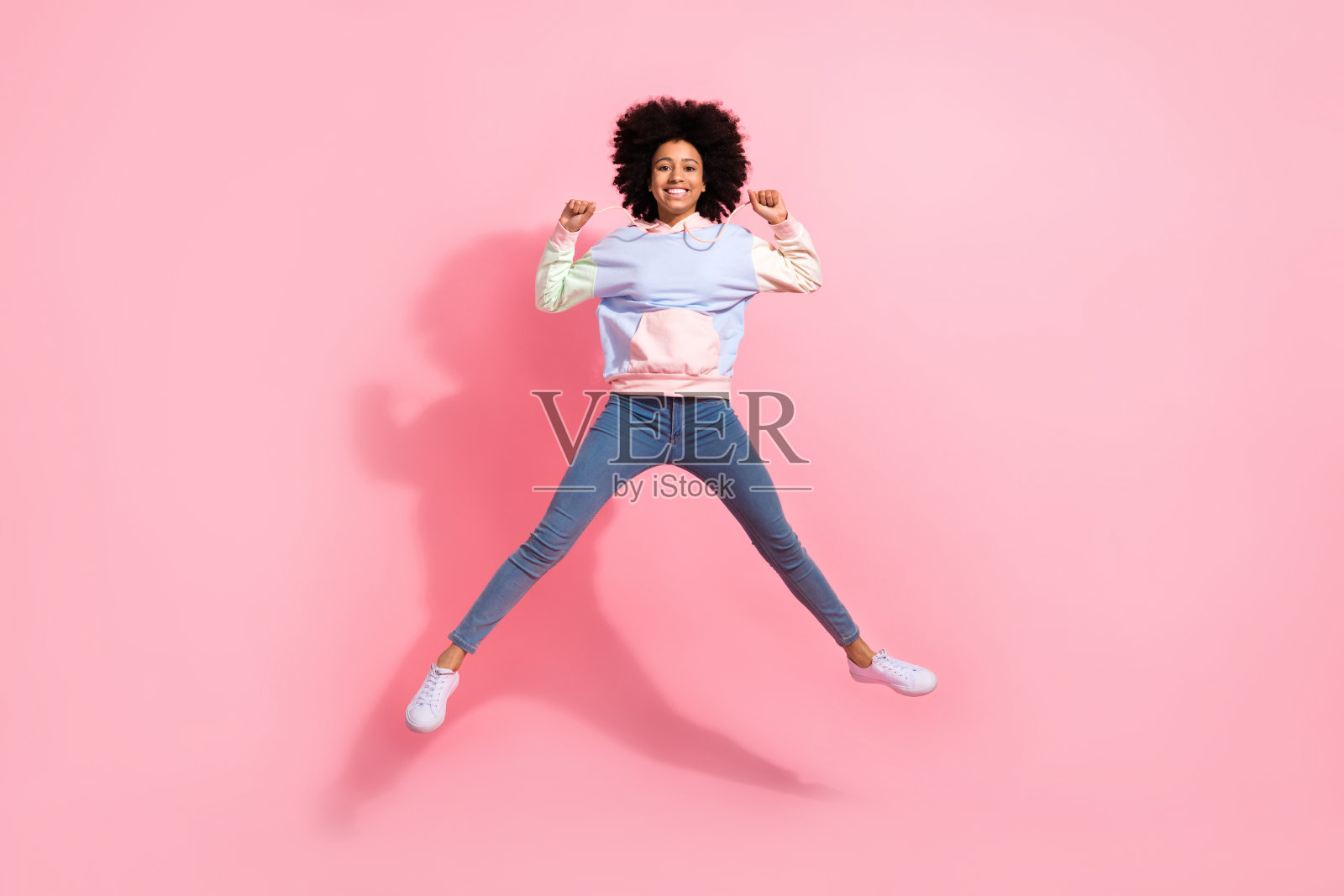 全身照片闪亮的幸运小孩穿运动衫上升的拳头跳跃高孤立的粉红色背景照片摄影图片