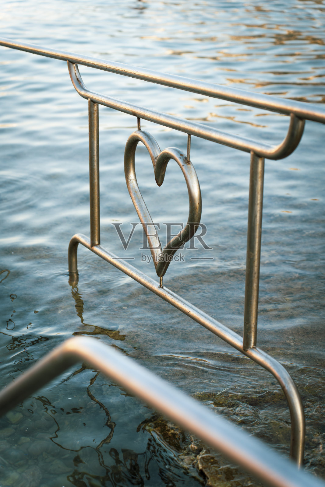 心形金属栏杆的水与温柔的波浪照片摄影图片