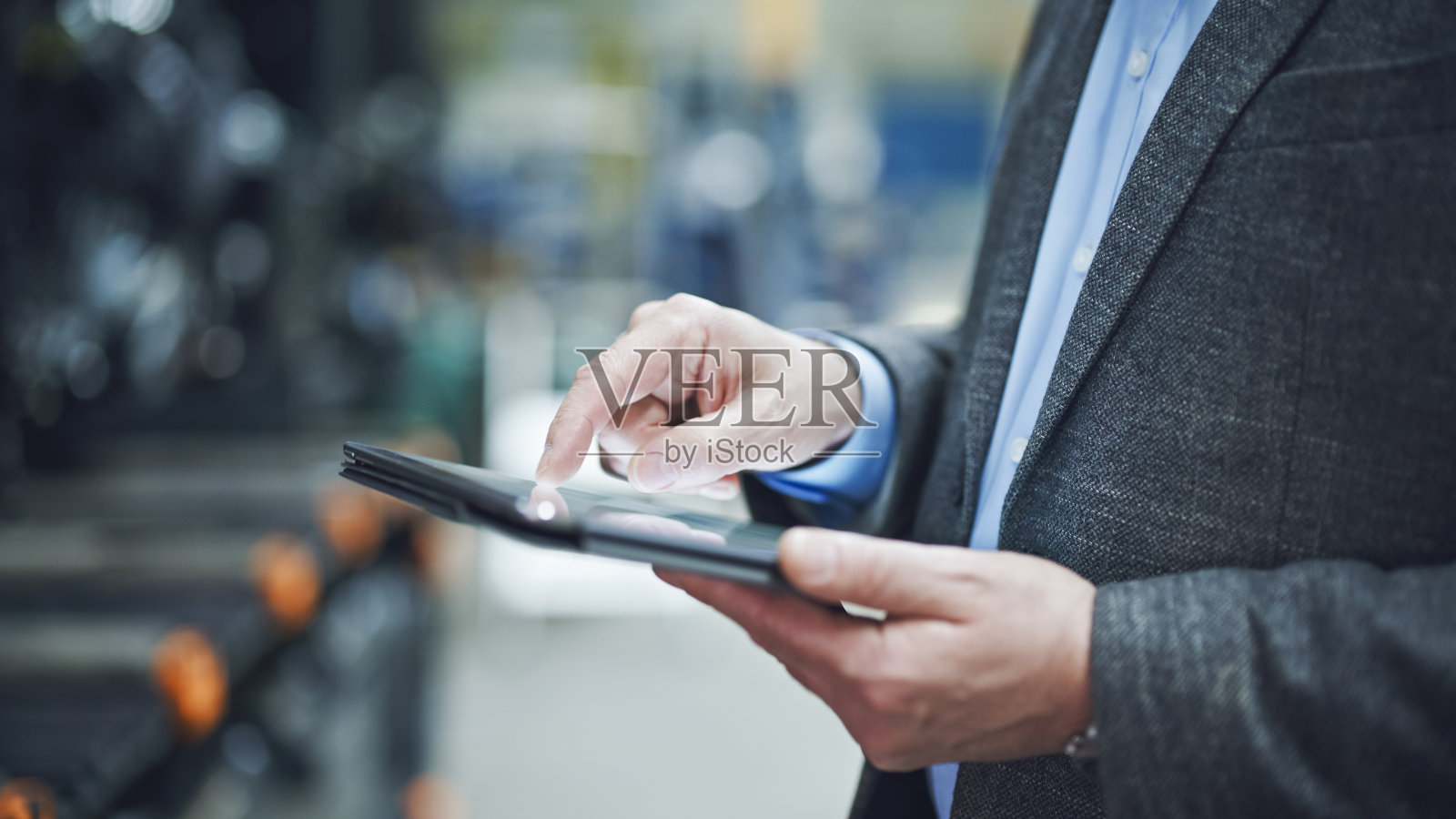 男督察在仓库使用平板电脑。图片展示了技术在管理库存和监督仓库运作中的作用照片摄影图片