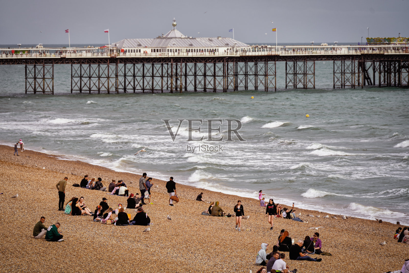 布莱顿宫码头和人们在布莱顿海滩沿英吉利海峡，布莱顿和霍夫，东苏塞克斯，英格兰南部海岸照片摄影图片