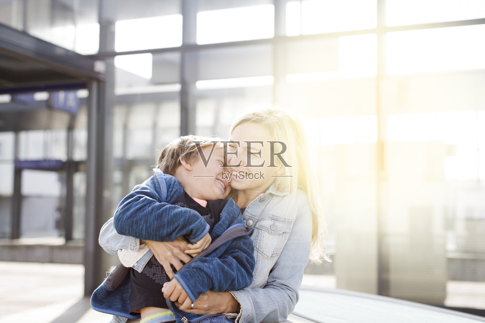 女人坐在家里拥抱男孩照片摄影图片