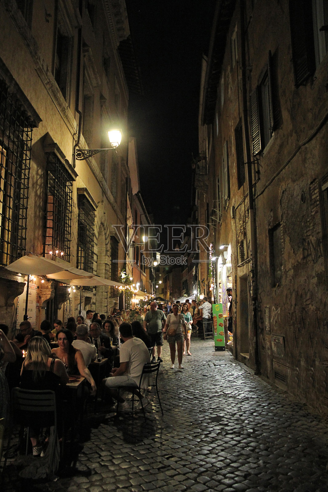 狭窄的意大利街与餐厅在特拉斯提弗莱区晚上在罗马,意大利照片摄影图片