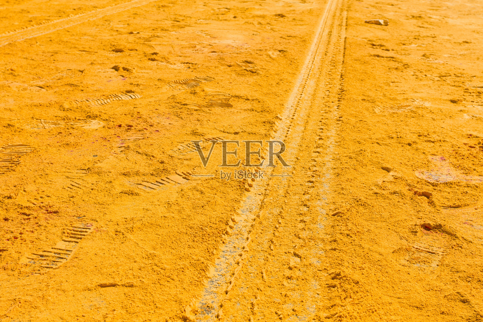 黄色粉末涂料与足迹和轮胎痕迹在道路上照片摄影图片