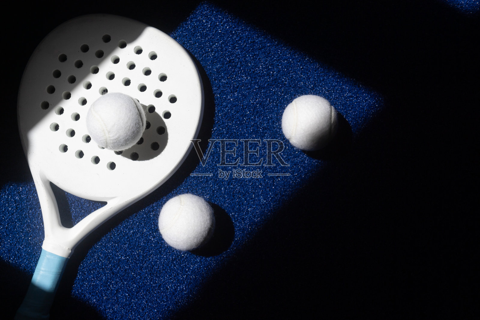 白色专业球拍网球拍和白色球与自然光线在蓝色背景。横向运动主题海报，贺卡，标题，网站和应用程序照片摄影图片