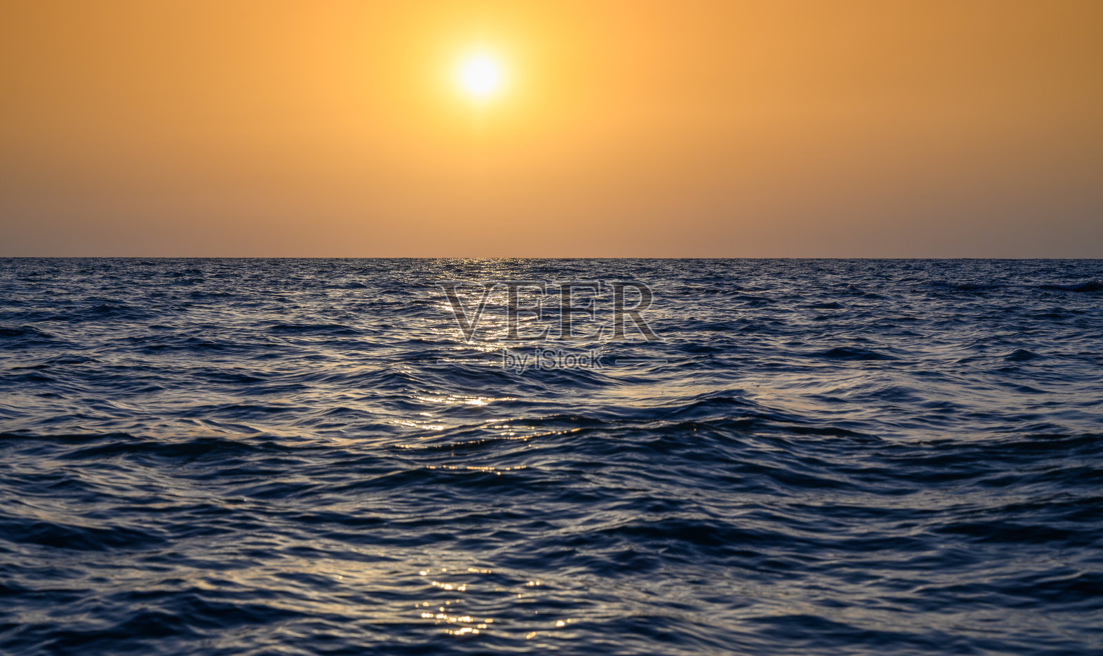 地中海温暖的海浪和日落时的沙滩照片摄影图片