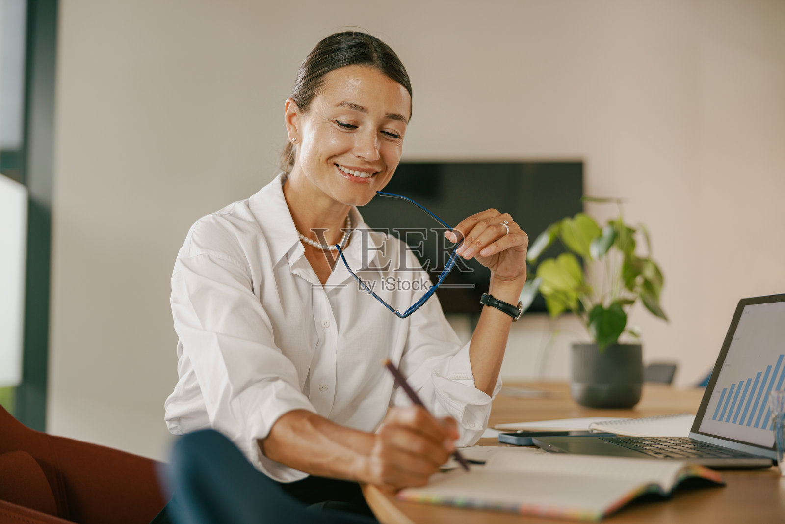 一位职业女性在现代办公环境中从事工作活动照片摄影图片