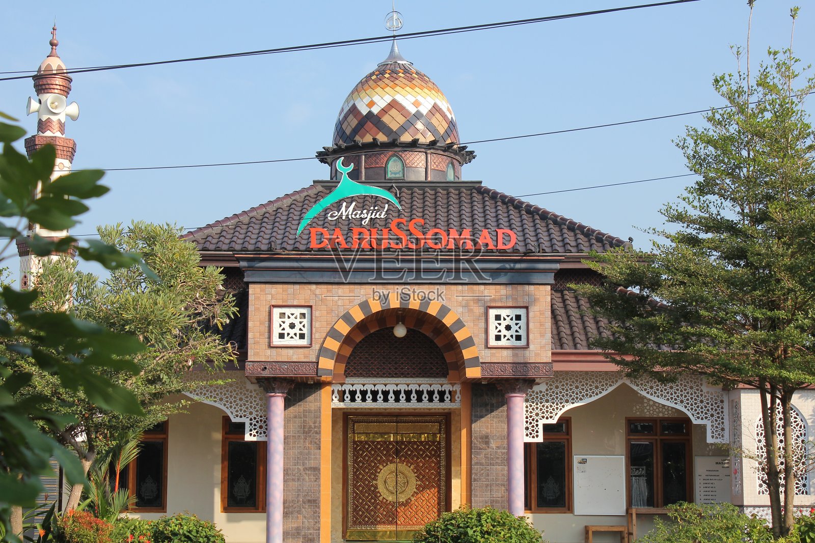 在Gawok村，树木环绕的经典达鲁索玛清真寺建筑照片摄影图片