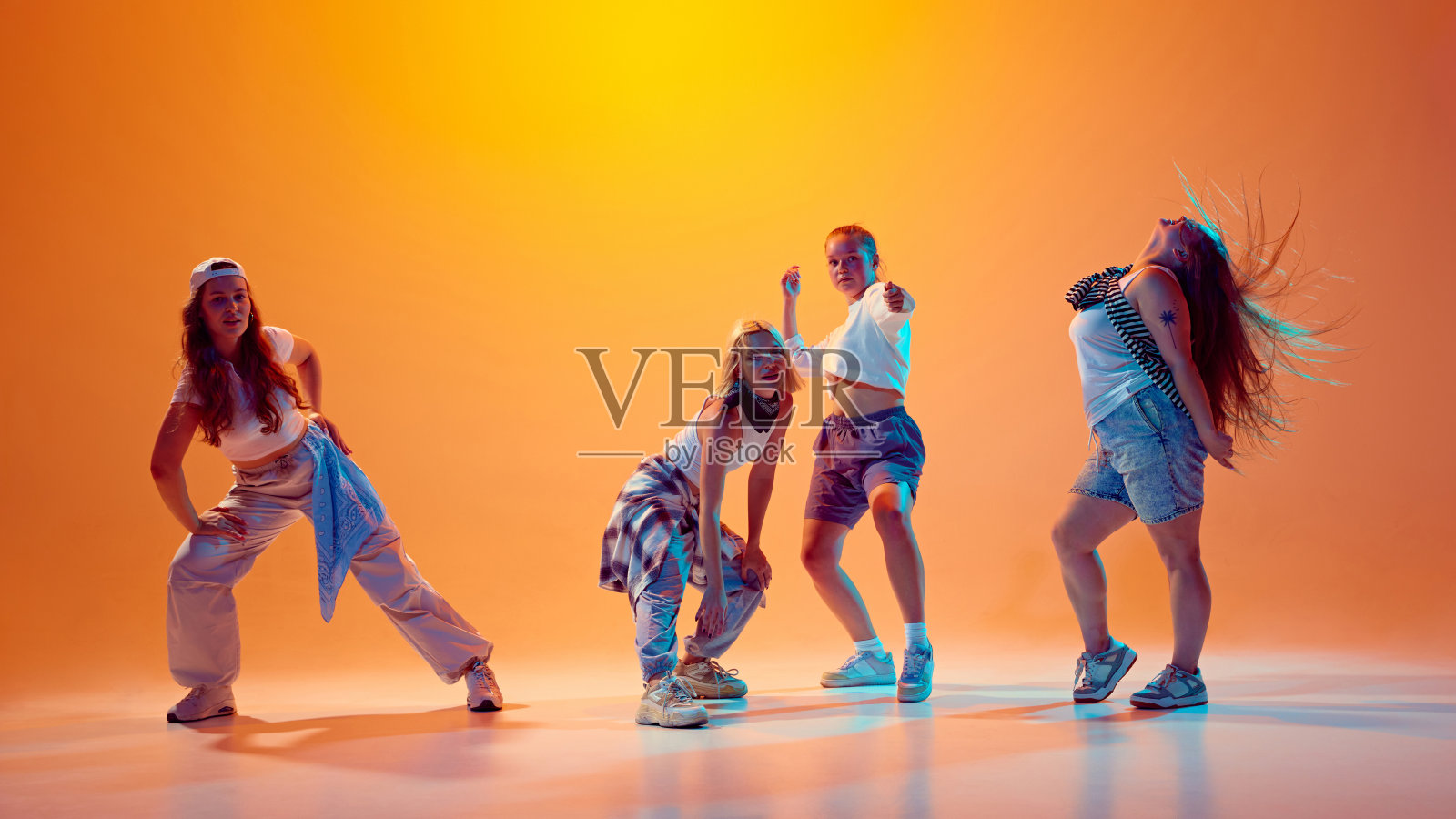 个性投掷动作。女孩，舞者跳舞，摆姿势穿着复古的衣服在充满活力的霓虹灯渐变工作室背景。照片摄影图片