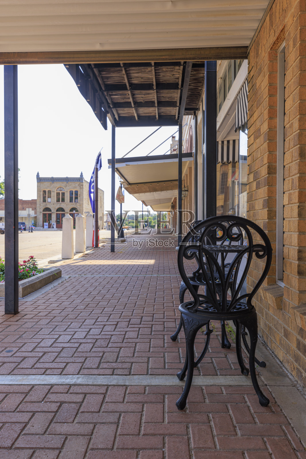 砖砌的阴影人行道两侧是古老的店面在哈勒茨维尔市中心,德克萨斯州。照片摄影图片