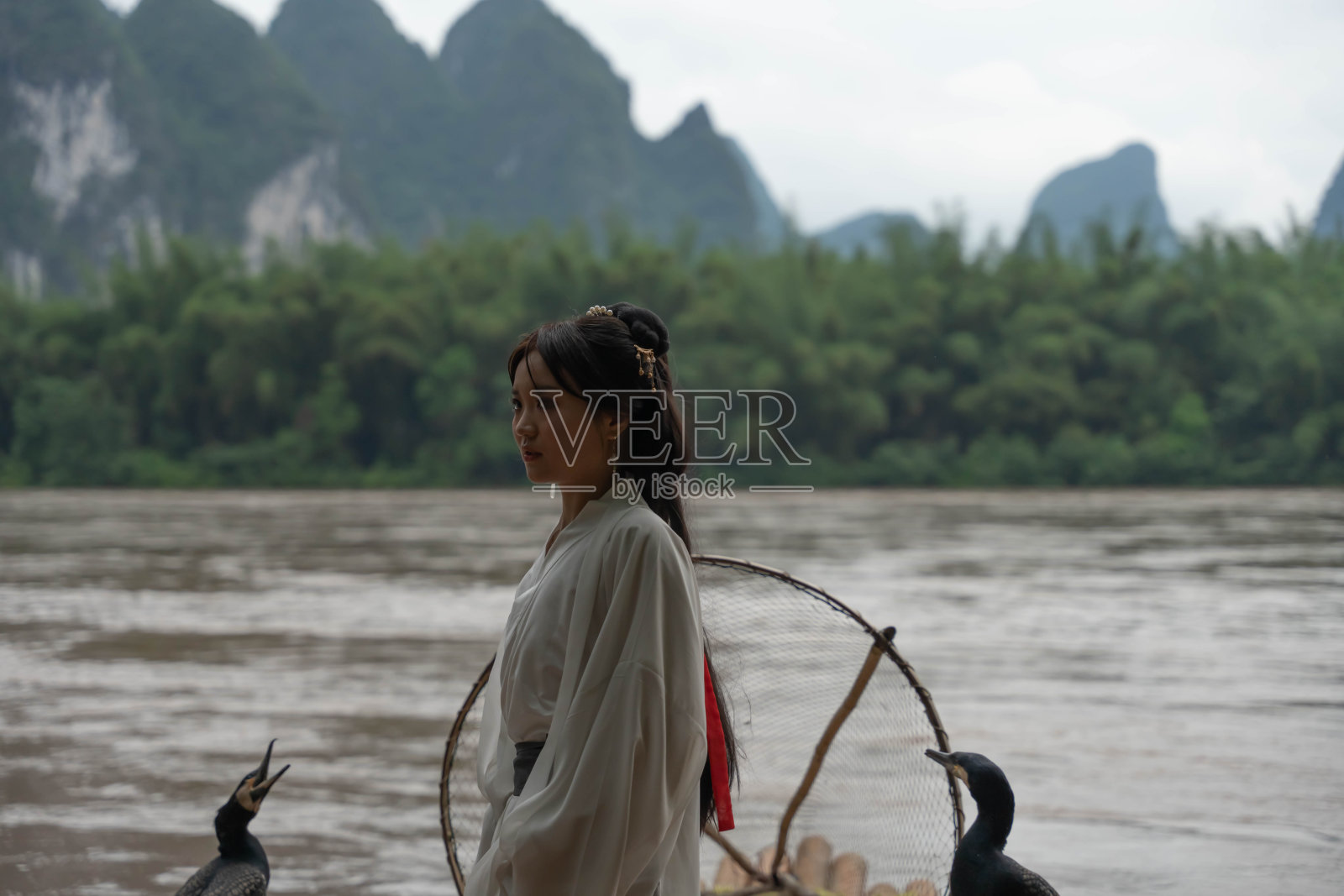 中国女孩在传统渔民的场景中整理长发。传统的服装照片摄影图片